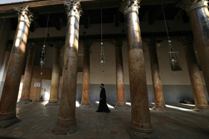 A priest walks in the virtually empty Church of the Nativity in the biblical city of Bethlehem -- thousands would normally visit the church ahead of Christmas