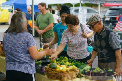 People shop for fresh produce and food at a farmer's market on June 29, 2021, in Homewood, Alabama