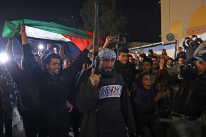 People celebrated while watching a television on a street in Khan Yunis, southern Gaza, as news of the ceasefire spread