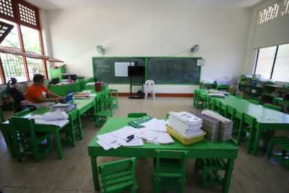 A teacher works inside an empty classroom after in-person classes were suspended due to dangerous heat in Iloilo City, central Philippines on April 2, 2024