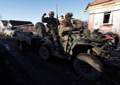 Russian soldiers ride a quad bike (ATV) in the village of Kazachya Loknya, which was previously held by Ukrainian troops and recently retaken by Russia's armed forces