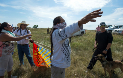 A Native American protestors holds up his arms as he and other protestors are threatened by private security guards and guard dogs, at a work site  for the Dakota Access Pipeline (DAPL) oil pipeline, near Cannon Ball, North Dakota, September 3, 2016