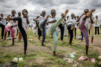Young refugee girls practice taekwondo kicks as they warm up for a recent performance in Kalobeyei