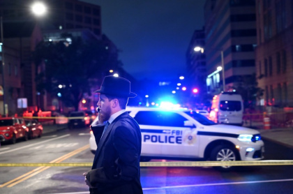 A man, standing behind police tape, talks on his cell phone outside the Capital Jewish Museum following a shooting that left two people dead, in Washington - Alex WROBLEWSKI (AFP) A man, standing behind police tape, talks on his cell phone outside the Capital Jewish Museum following a shooting that left two people dead, in Washington - Alex WROBLEWSKI (AFP)
