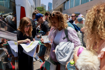 People register before the departure of a bus slated to evacuate foreign passport holders, mainly European, out of Israel, at a meeting point in Tel Aviv - Menahem KAHANA (AFP) People register before the departure of a bus slated to evacuate foreign passport holders, mainly European, out of Israel, at a meeting point in Tel Aviv - Menahem KAHANA (AFP)