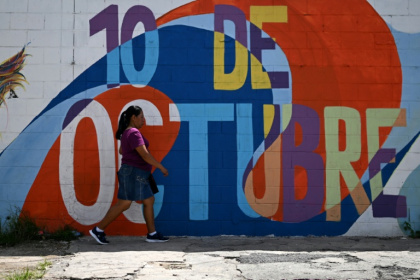 A woman walks in front of a mural in the 10 de Octubre district, a former gang stronghold in El Salvador - Marvin RECINOS (AFP) A woman walks in front of a mural in the 10 de Octubre district, a former gang stronghold in El Salvador - Marvin RECINOS (AFP)