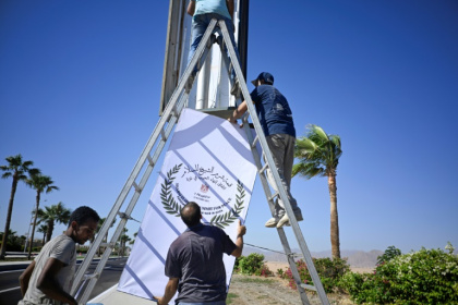 Municipal workers hang a sign advertising the upcoming US- and Egyptian-hosted Gaza peace summit in Sharm el-Sheikh - Khaled DESOUKI (AFP) Municipal workers hang a sign advertising the upcoming US- and Egyptian-hosted Gaza peace summit in Sharm el-Sheikh - Khaled DESOUKI (AFP)