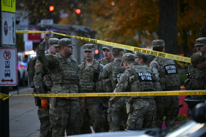 National Guard soldiers stand behind crime scene tape at a corner in downtown Washington where two National Guard soldiers were shot just blocks from the White House - Drew ANGERER (AFP)