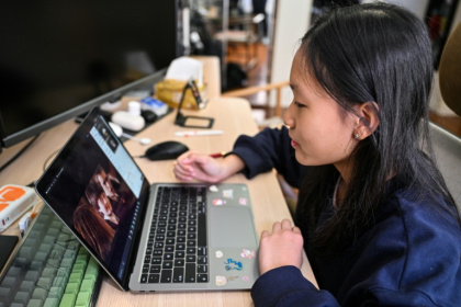 Estella, 14, a homeschooled student, does a Spanish class from her bedroom in Shanghai - Hector RETAMAL (AFP)