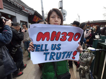 A family member of a Chinese passenger from the missing Malaysia Airlines flight MH370 leaves after a prayer session at the Yonghegong Lama temple in Beijing on March 8, 2015 - Goh Chai Hin (AFP)
