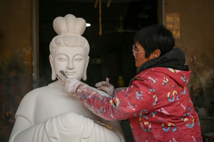 In the village of Chongshan generations of residents have made a living creating Buddhist and Taoist sculptures - Jade GAO (AFP)