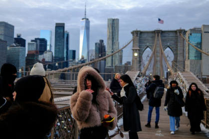 People brave the cold on the Brooklyn Bridge in New York City ahead of Winter Storm Fern - CHARLY TRIBALLEAU (AFP)