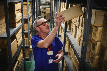 Consultant gastroenterologist Kevin Monahan looks through boxes of bowel cancer specimens at St Mark's hospital, west London, a unique record taken from patients over the past century - Adrian DENNIS (AFP)