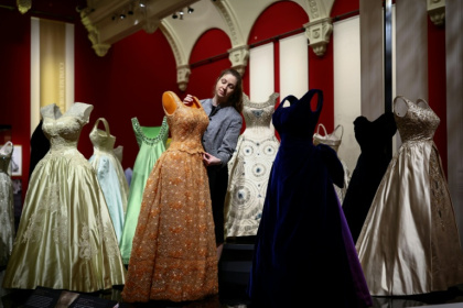 A staff member puts the finishing touches to the exhibition 'Queen Elizabeth II: Her Life in Style' which is opening in London's Buckingham Palace - Henry NICHOLLS (AFP)