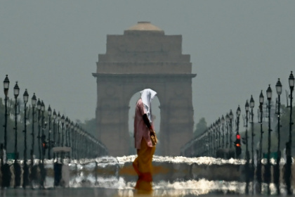 Summer heat in the world's most populous nation can be brutal -- here a woman walks past India Gate in New Delhi in June 2025 - Arun SANKAR (AFP)