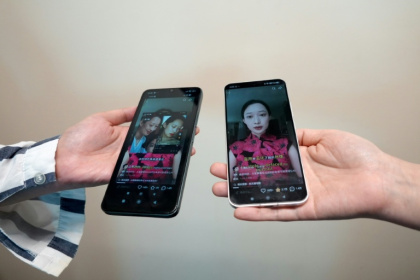 This photo illustration taken in Hong Kong shows phones displaying screenshots of a video from Chinese model and influencer Christine Li accusing an AI microdrama of stealing her likeness without consent - Mahmoud RIZK (AFP)