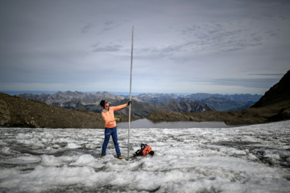 Matthias Huss with a four-metre-long measuring stake indicating the amount of ice that melted over the past year on the Scex Rouge glacier - Fabrice COFFRINI (AFP)