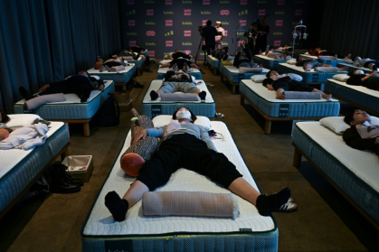 Attendees take part in a sleep competition organised by a mattress brand in Tokyo on October 5, 2026. - Selim CHTAYTI (AFP)